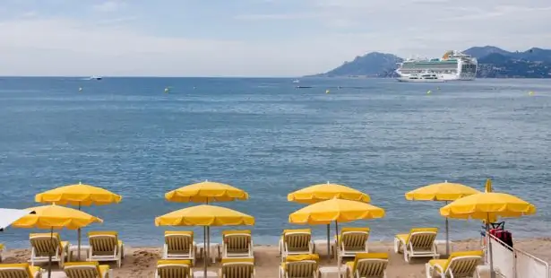 Une plage équipée de transats devant un établissement balnéaire