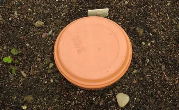 Oya en terre cuite fermée par un couvercle dans un jardin